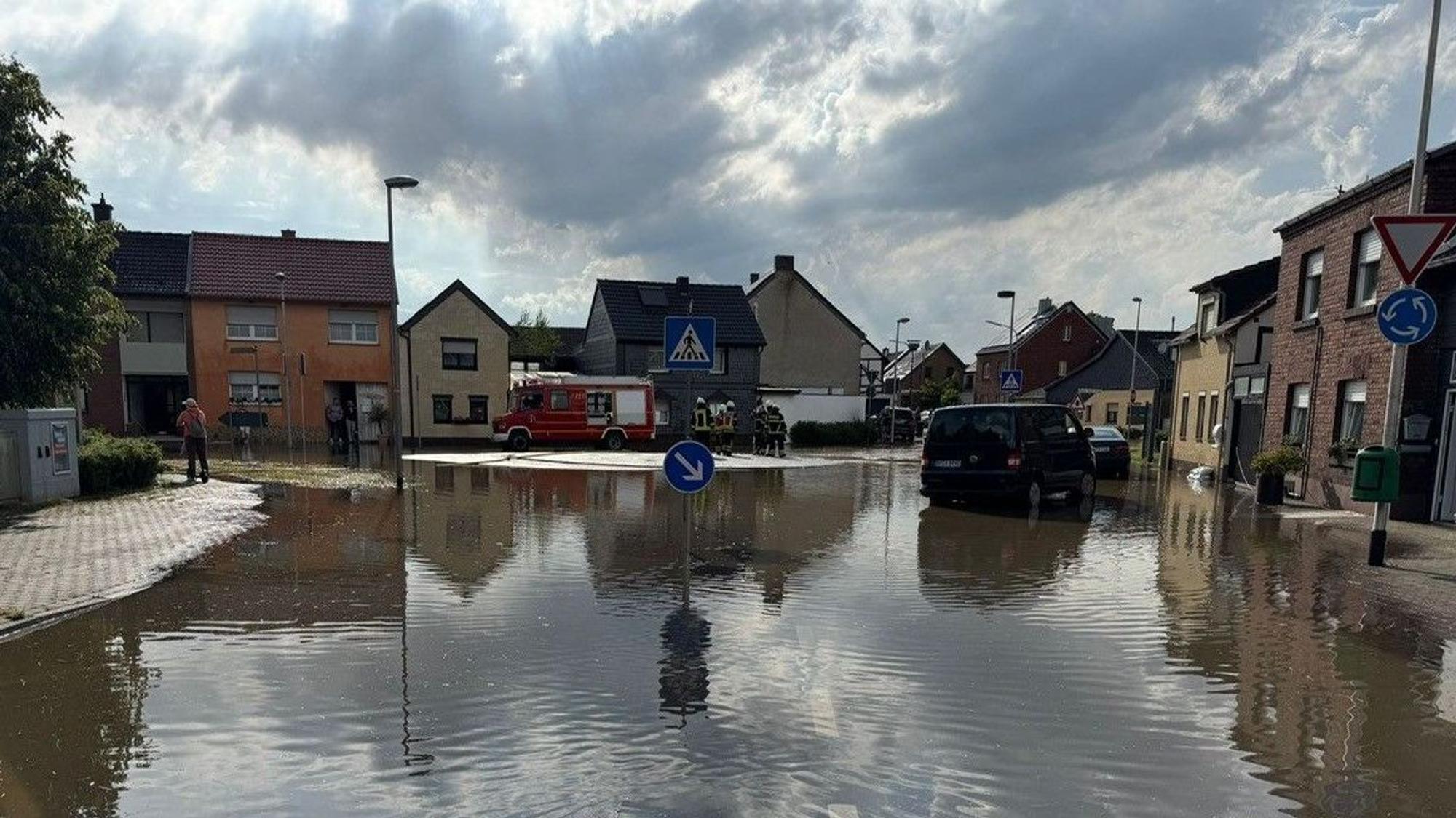 Das Bild zeigt einen Dorfplatz, der unter Wasser steht.