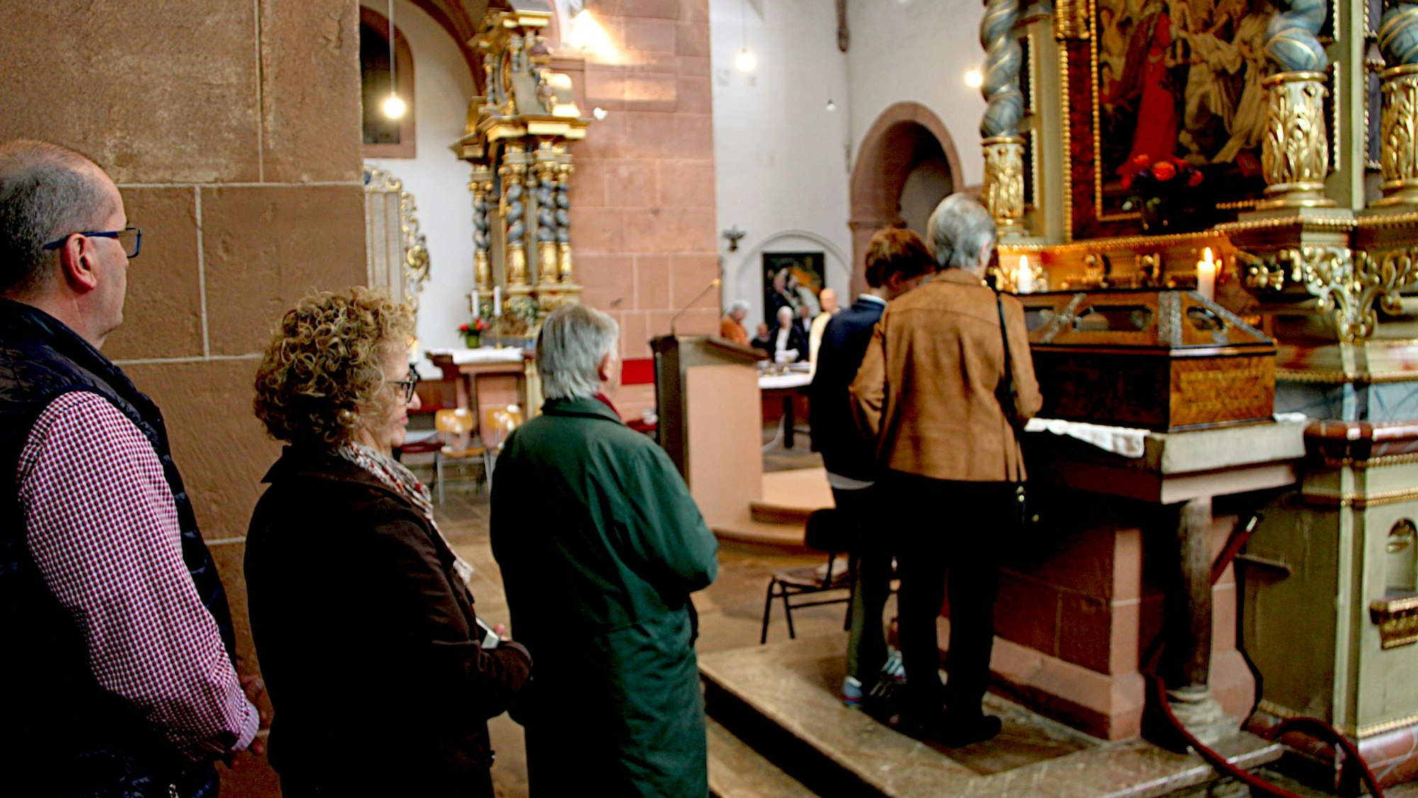 Vor dem aufgebahrten Holzsarg haben sich Gläubige aufgereiht.