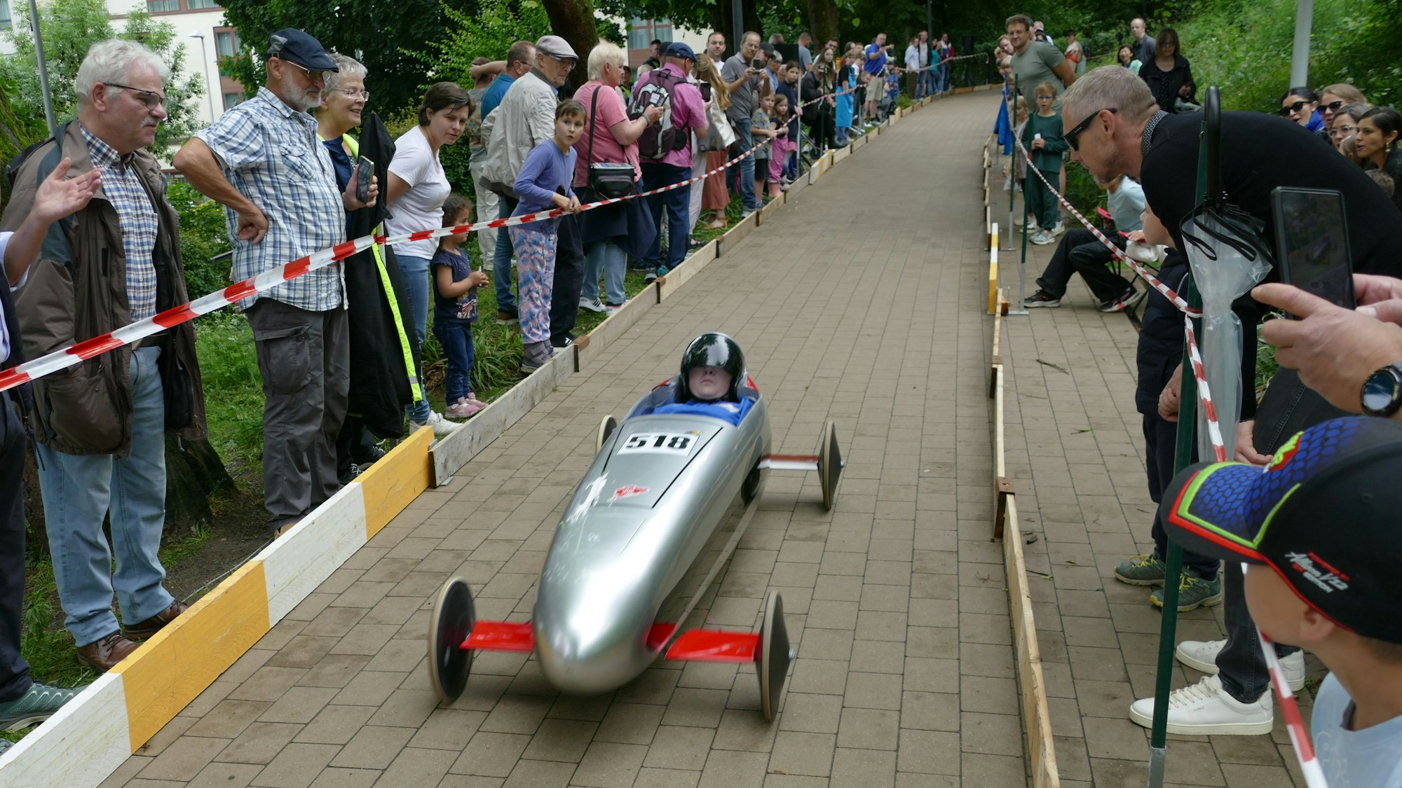 Viele Zuschauerinnen und Zuschauer warten am Zieleinlauf auf die Seifenkistenfahrer.