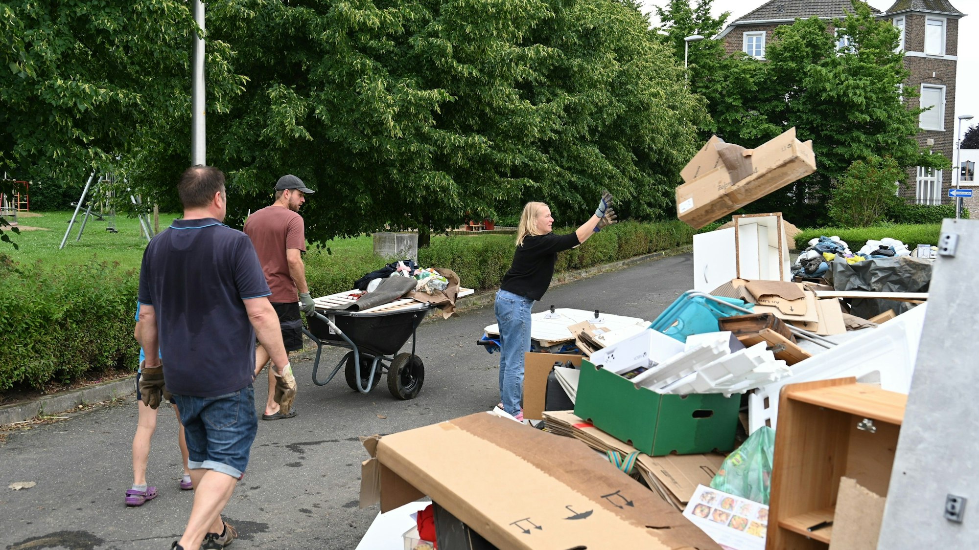 Menschen räumen Sperrmüll weg.