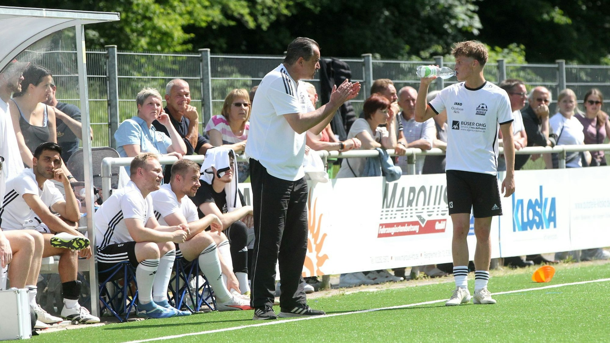 Nierfelds Trainer Dirk Scheer applaudiert, sein Spieler Yannick Schorn trinkt.