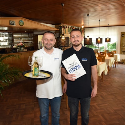 Der Retsina ist gut gekühlt: Im Service des Restaurants „Olympia“ in Wiehl-Oberwiehl sind ab sofort Naser Ruhani (links) und sein Sohn Kushtrim unterwegs. Die Gaststätte ist am Wochenende wiedereröffnet worden.