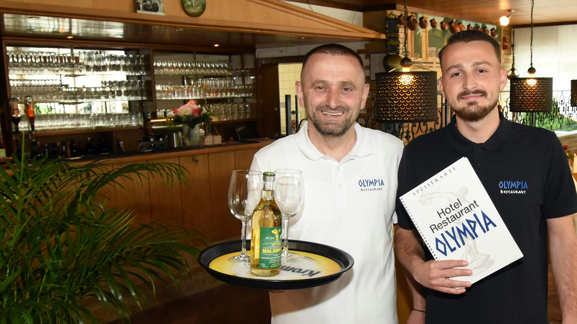 Der Retsina ist gut gekühlt: Im Service des Restaurants „Olympia“ in Wiehl-Oberwiehl sind ab sofort Naser Ruhani (links) und sein Sohn Kushtrim unterwegs. Die Gaststätte ist am Wochenende wiedereröffnet worden.