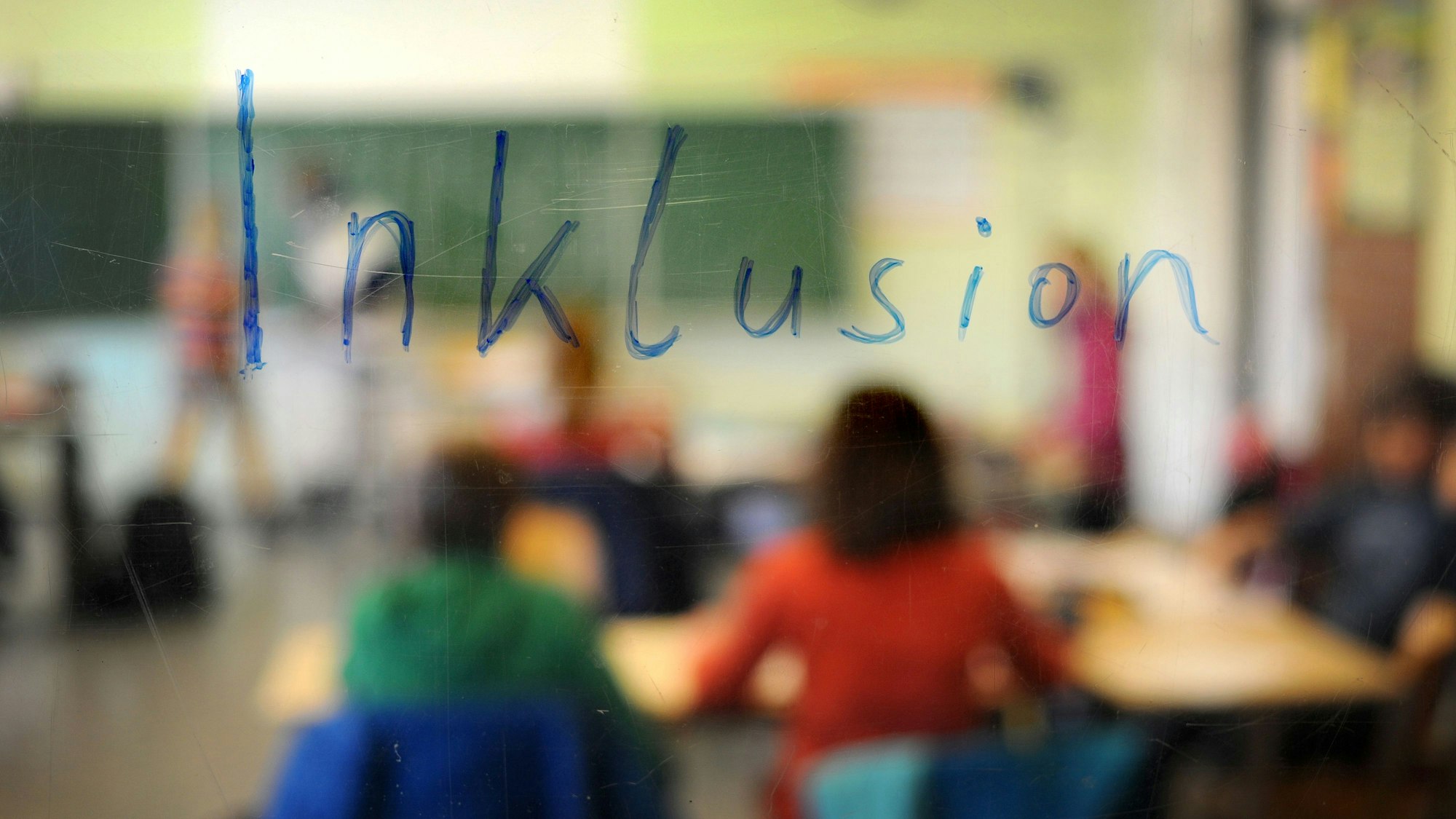 Schüler sitzen am in einer Inklusions-Klasse unter dem Schriftzug „Inklusion“. (Archivbild)