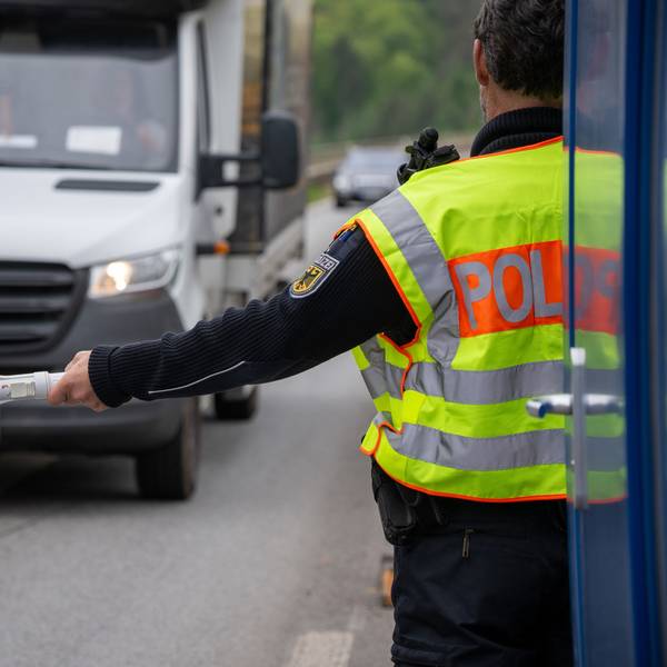 Ein Polizist hält einen Transporter auf der A64 an. (Symbolbild)
