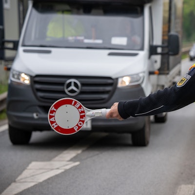 Ein Polizist hält einen Transporter auf der A64 an. (Symbolbild)