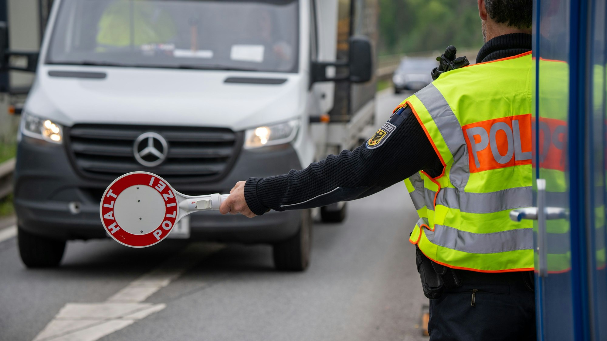 Ein Polizist hält einen Transporter auf der A64 an. (Symbolbild)