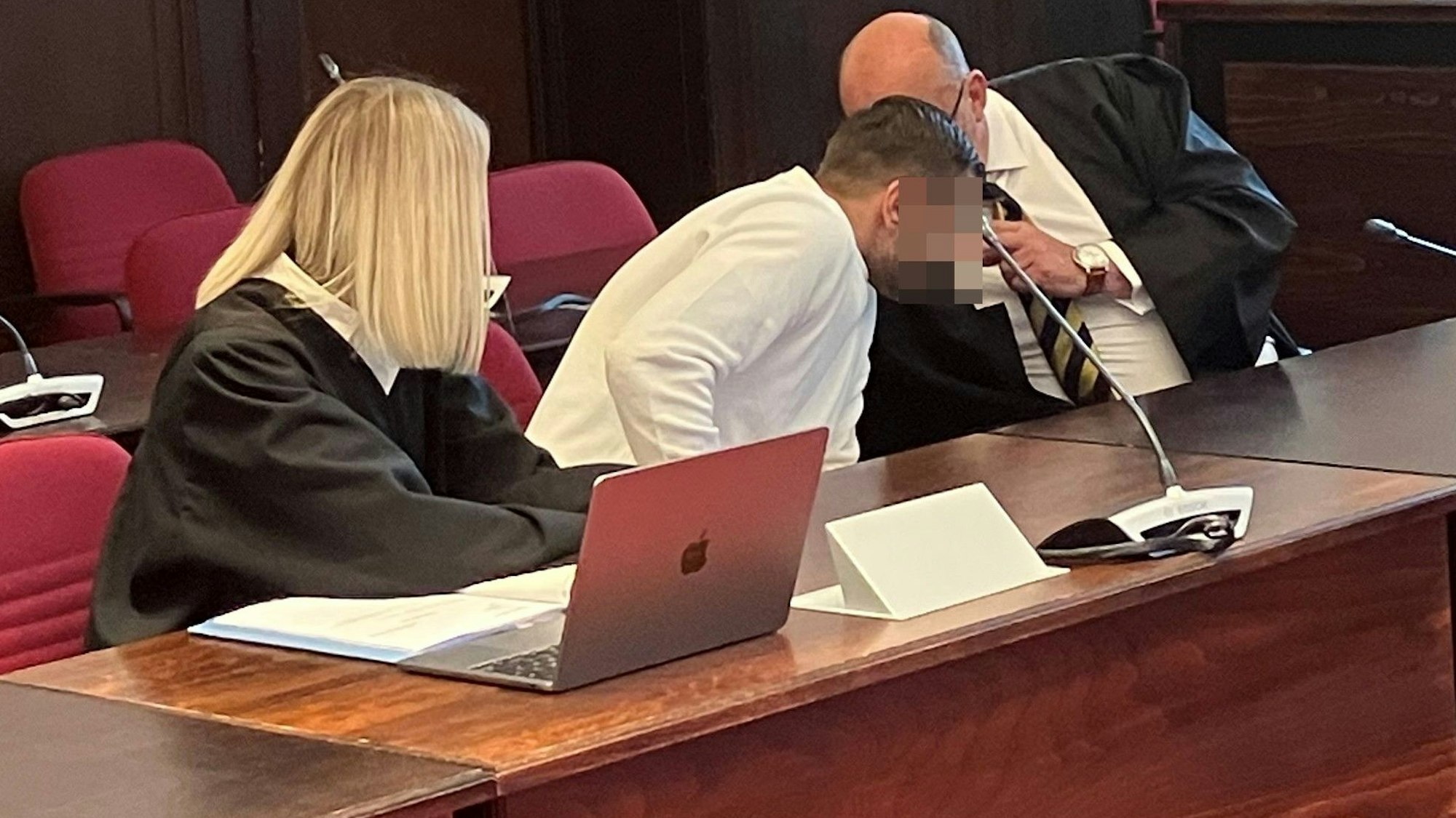 Verteidiger Uwe Krechel spricht zum Angeklagten, seine Kollegin hört zu.