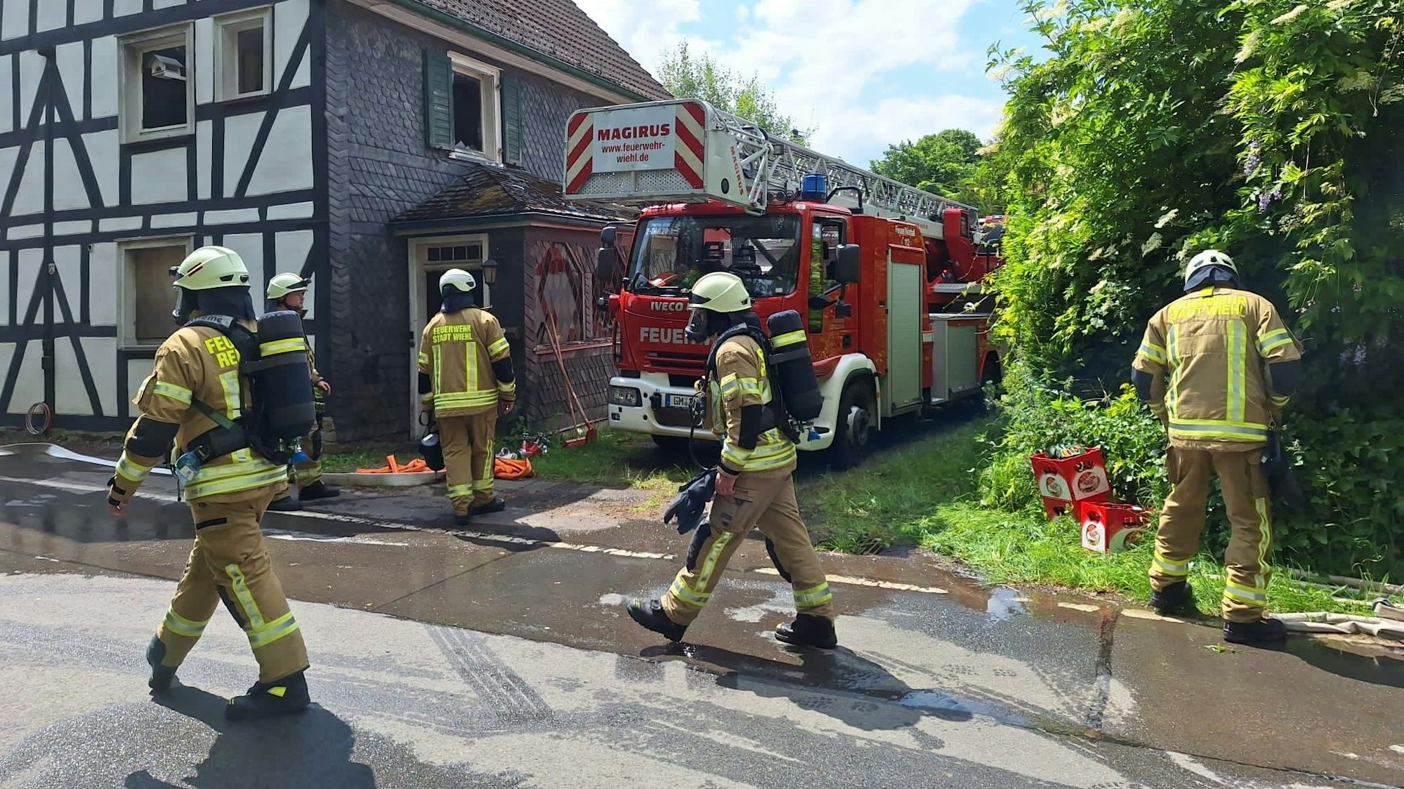 Feuerwehrleute vor dem Wohnhaus.