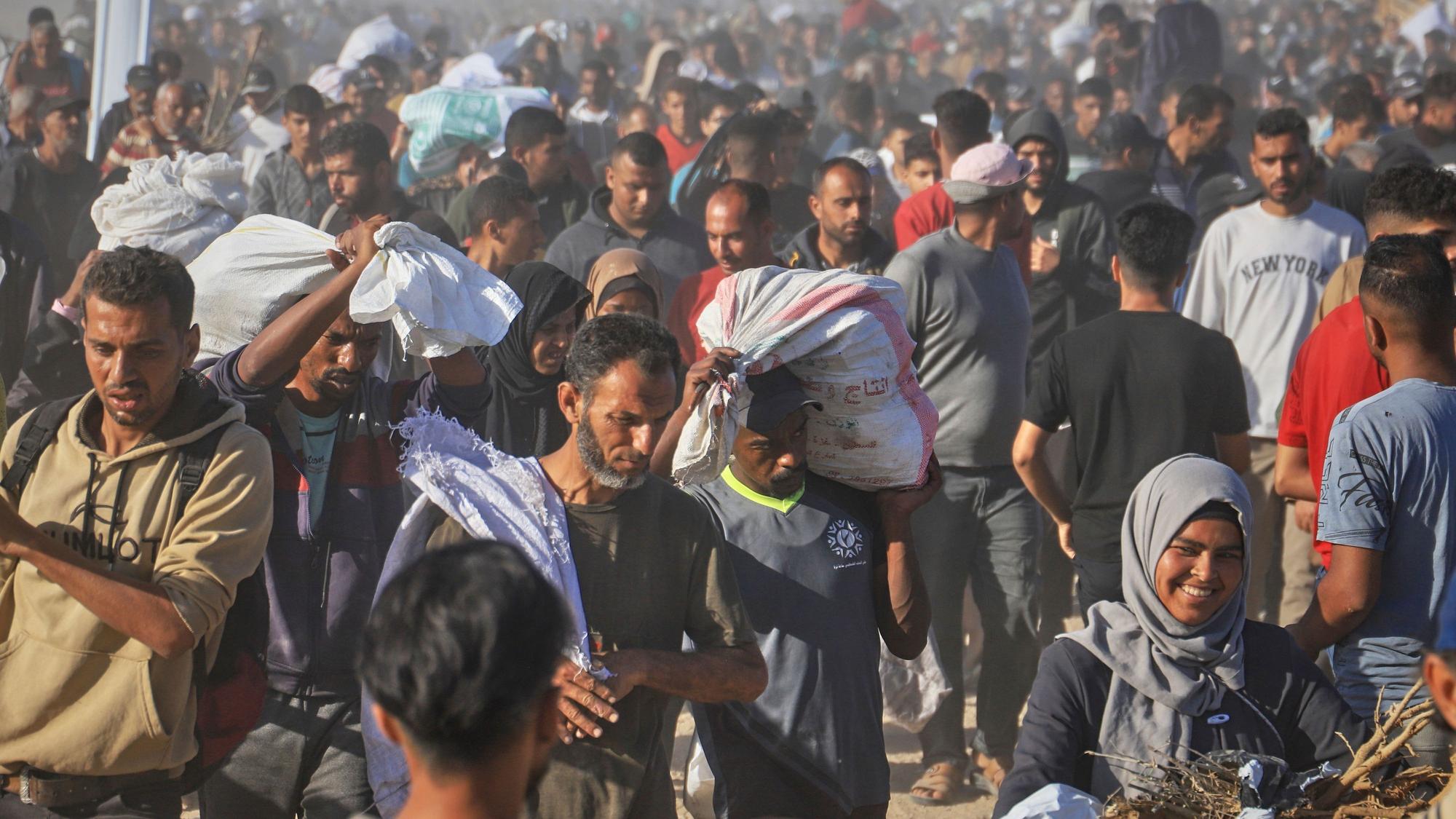 Palästinenser tragen in Rafah im südlichen Gazastreifen Kisten und Taschen mit Lebensmitteln und humanitären Hilfspaketen, die von der Gaza Humanitarian Foundation, einer von Israel anerkannten und von den USA unterstützten Organisation, geliefert wurden.
