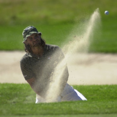 Ein Golfspieler schlägt einen Ball.