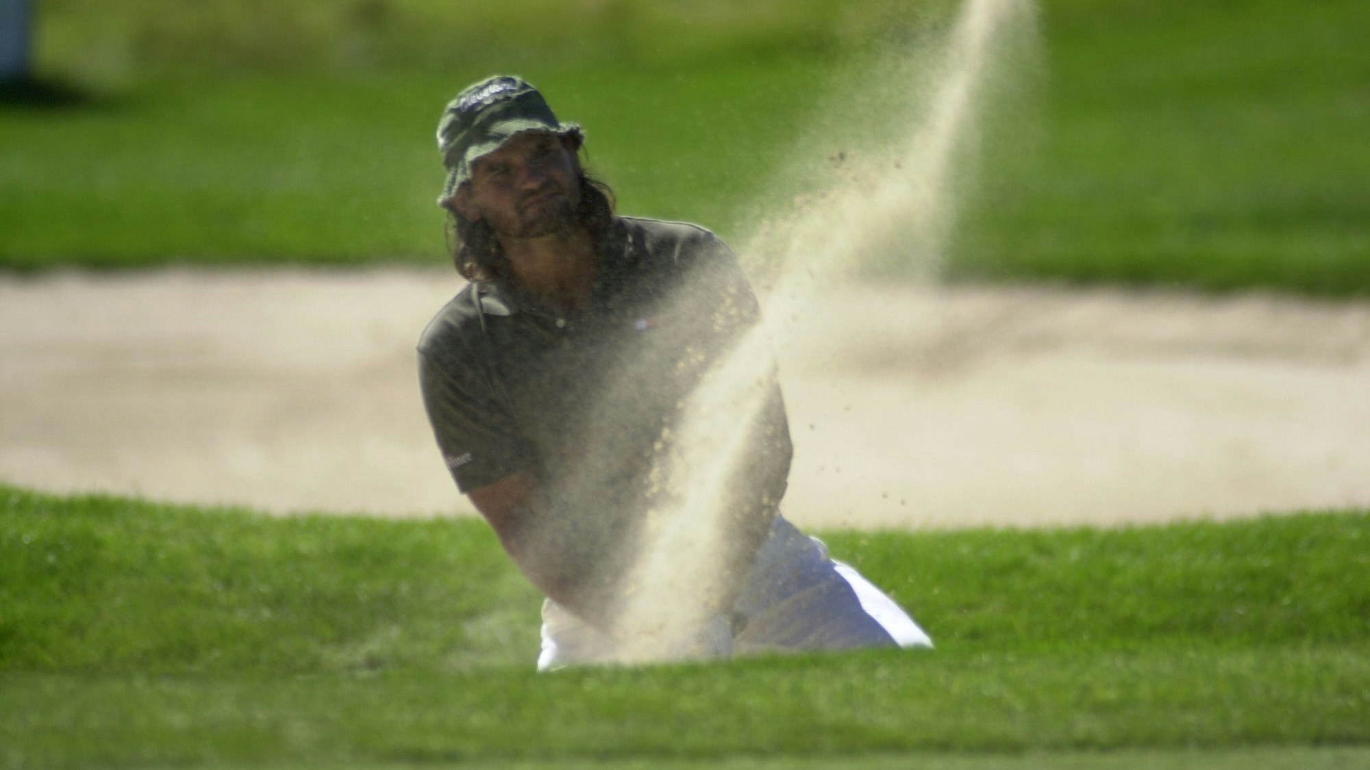 Ein Golfspieler schlägt einen Ball.