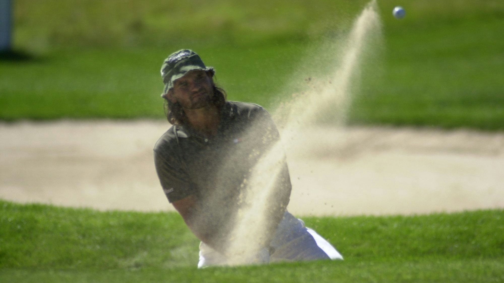 Ein Golfprofi schlägt einen Ball.