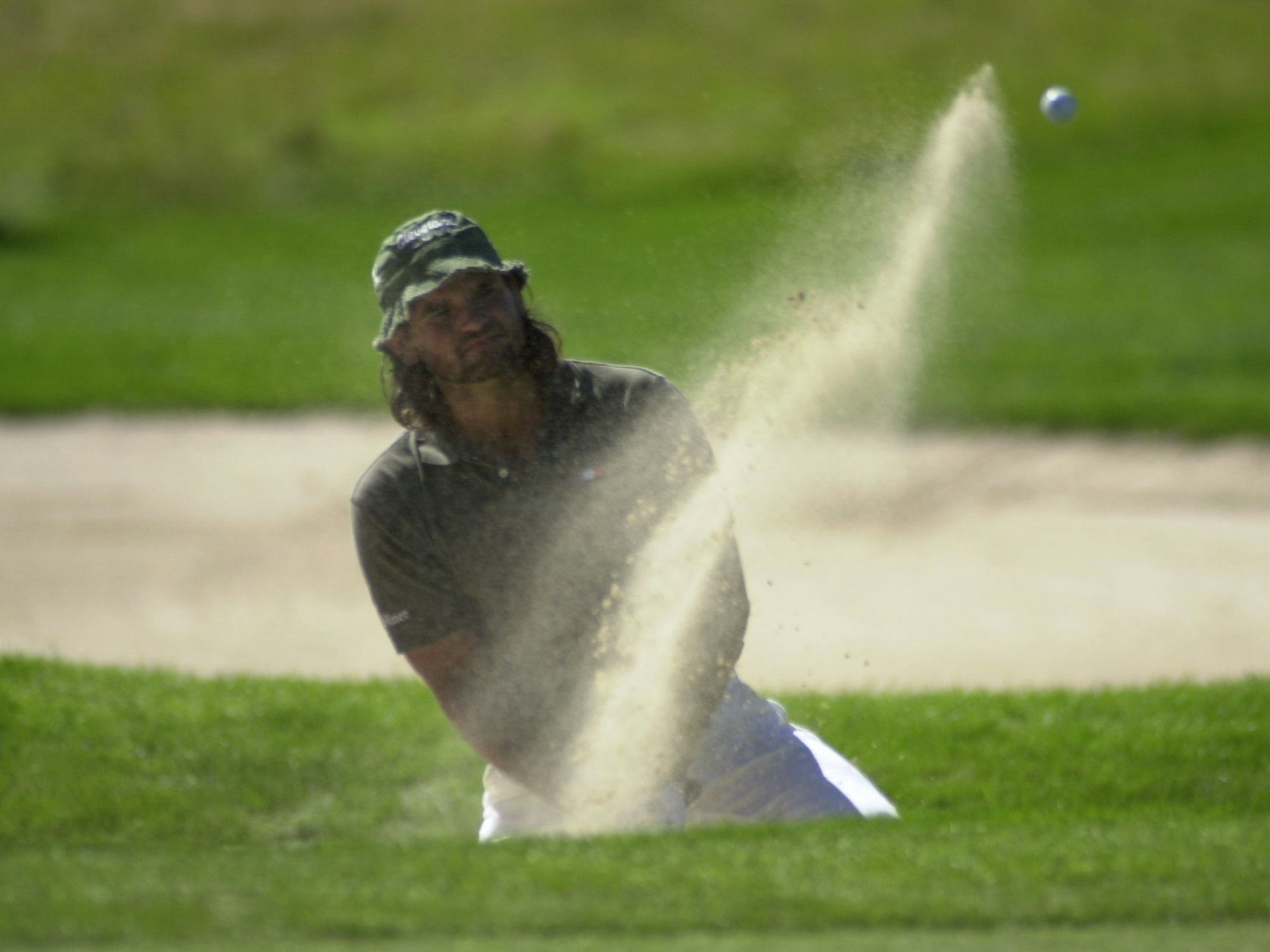 Ein Golfspieler schlägt einen Ball.