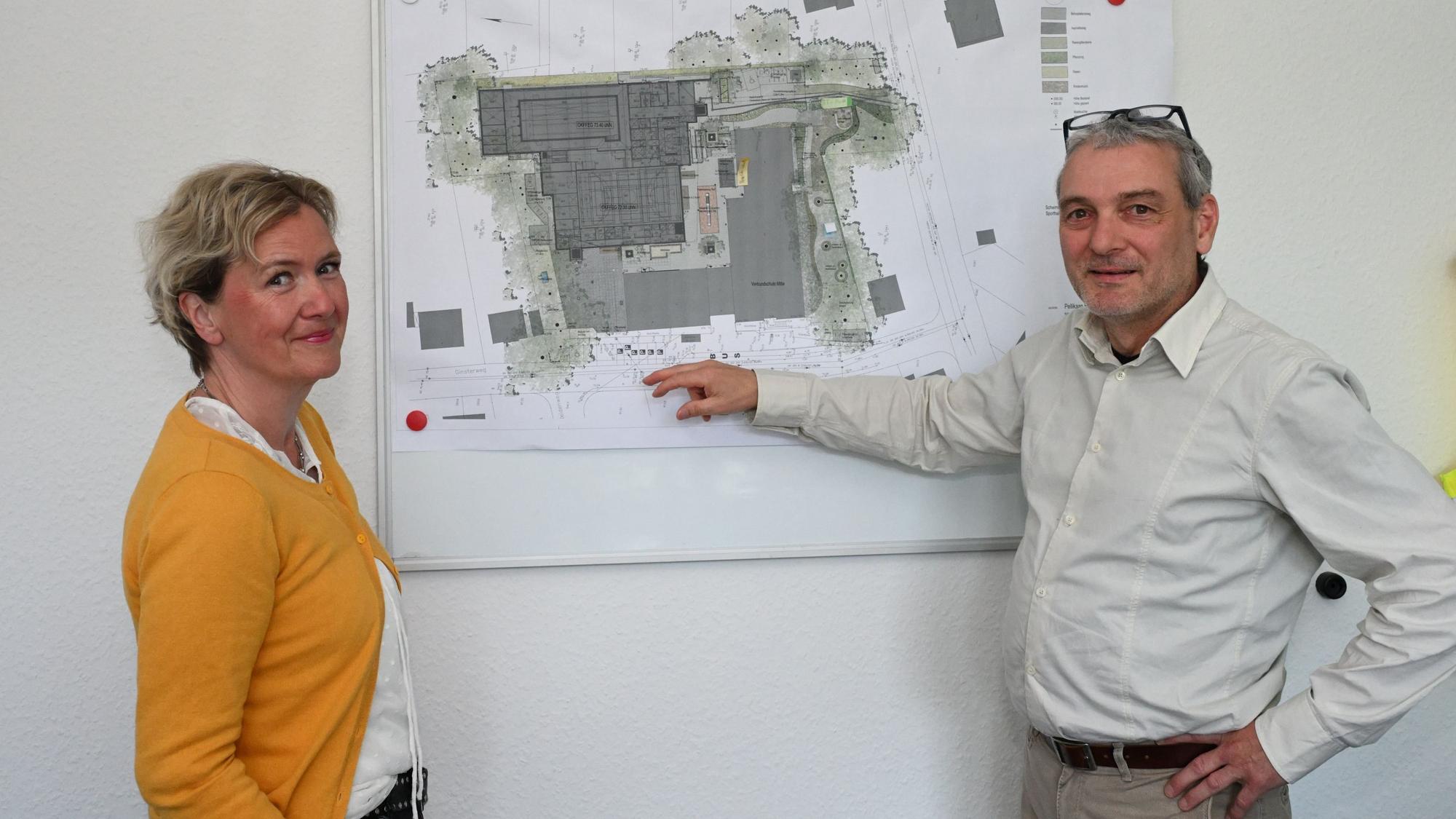 Sandra Orth, Elternvertreterin, und Philipp Nagel, Leiter der Förderschule in Refrath, zeigen auf dem Plan, wie eng es aktuell auf dem Schulhof ist.