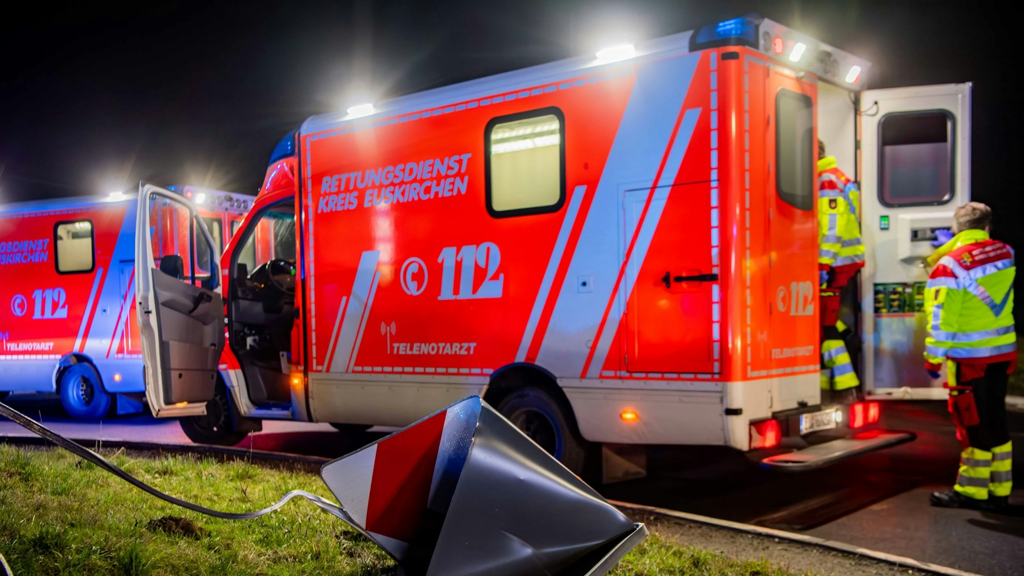 Zwei Rettungswagen mit der Aufschrift „Rettungsdienst Kreis Euskirchen“ sind im Dunkeln hintereinander geparkt.