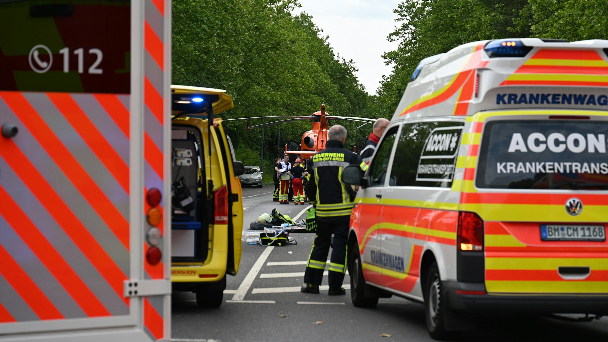 Das Foto zeigt Rettungsfahrzeuge, dahinter einen Hubschrauber.