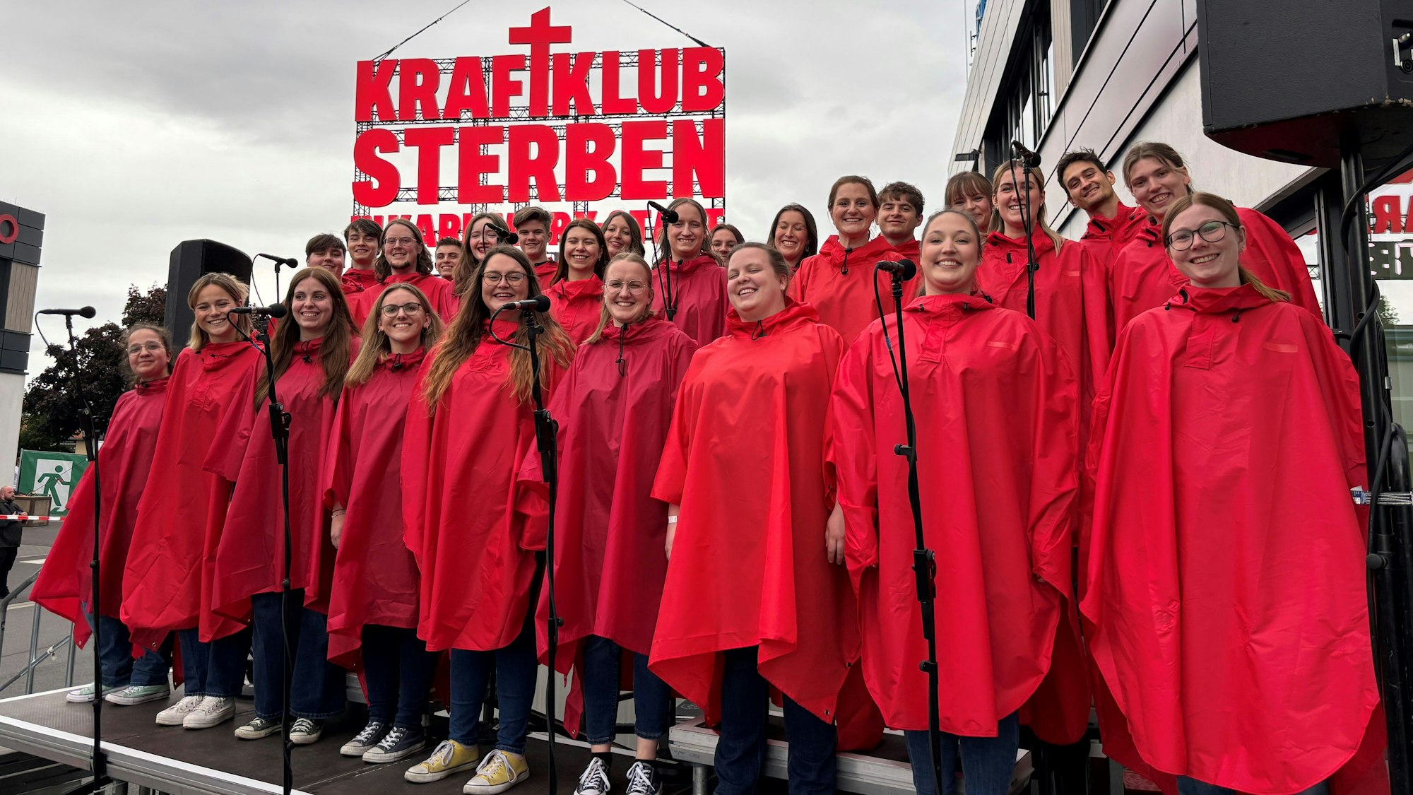 Der Jugendchor St. Stephan auf einer Tribüne zwischen hunderten Kraftklub-Fans.