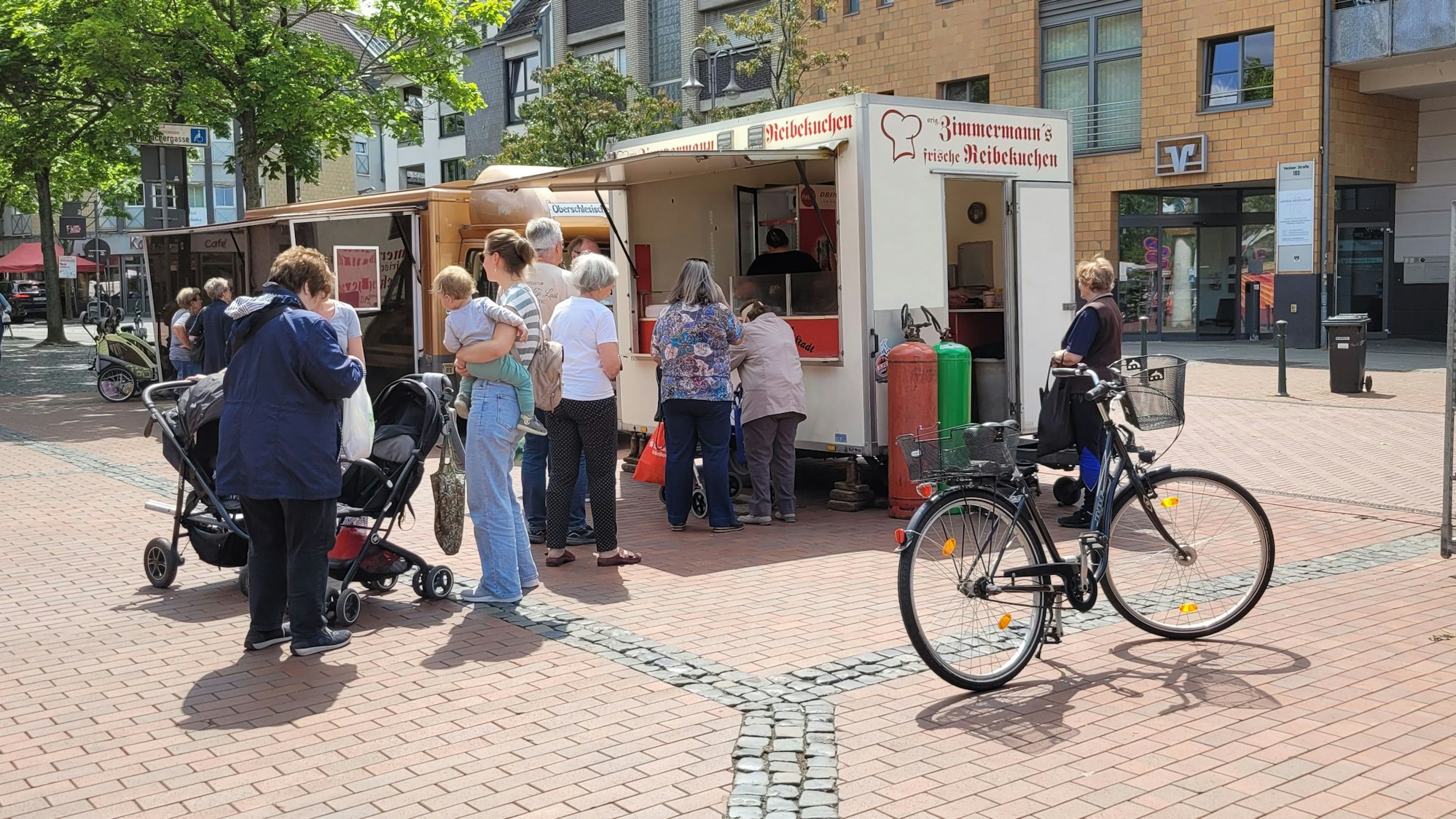 Vor einem Reibekuchenstand stehen die Kunden Schlange.