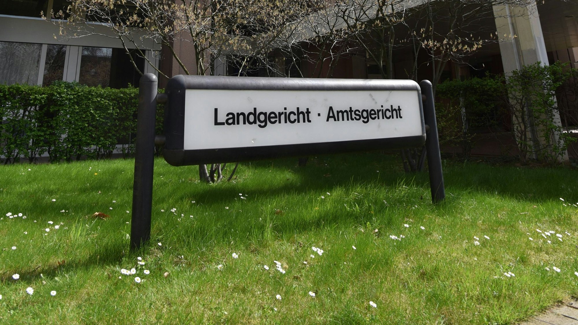 Ein Schild verweist auf das Landgericht und Amtsgericht Köln am Eingang vor dem Gebäude.