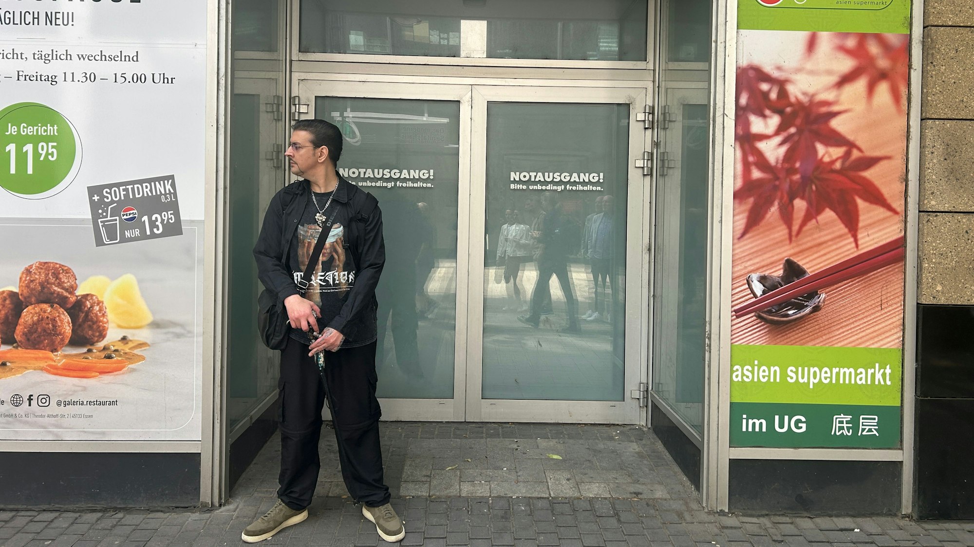 Ein Mann steht vor einem Hauseingang in der Innenstadt