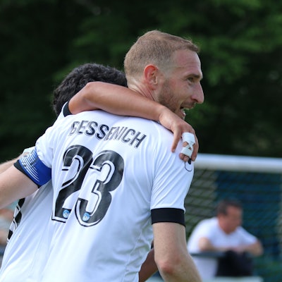 Moritz Hartmann lacht, ein Mitspieler hat ihm den Arm um die Schultern gelegt.