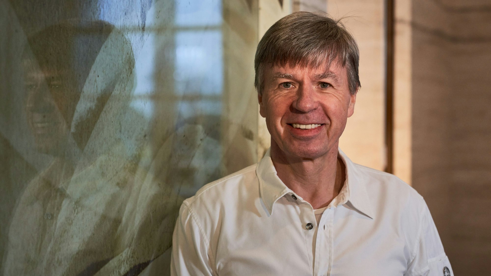 Ein Mann mittleren Alters lächelt in die Kamera.