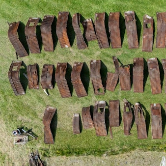 Die großen rostigen Blechteile sind sortiert, viele müssen repariert werden, bevor sie wieder zusammengebaut werden können.