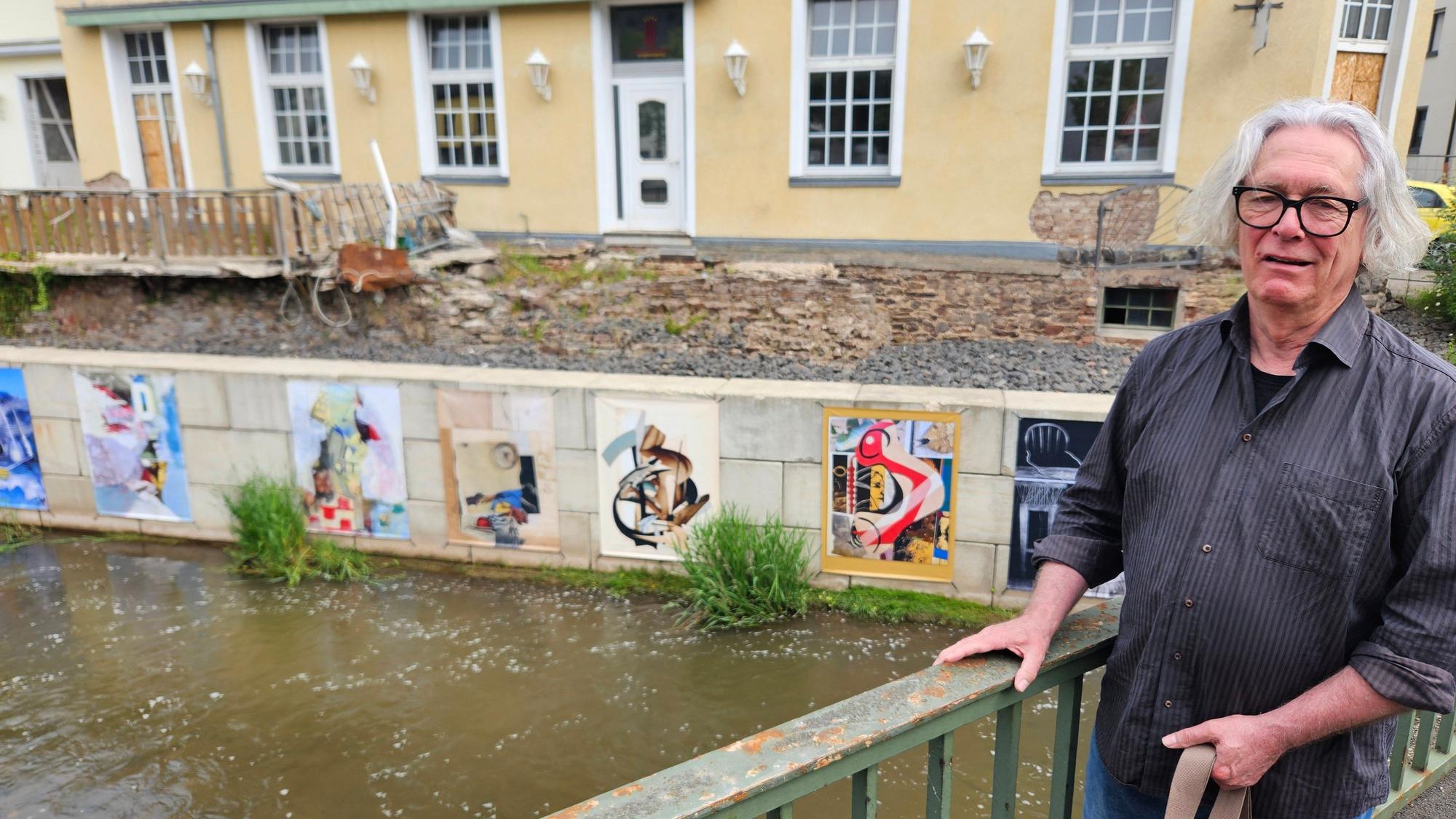 Jürgen A. Roder steht an einem Geländer. Im Hintergrund sind einige Kunstwerke zu sehen.
