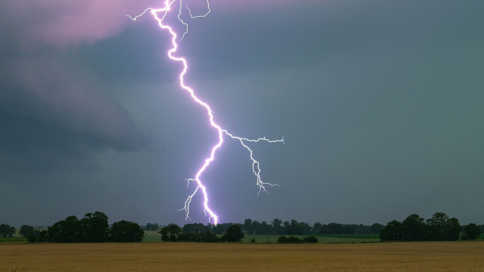 ARCHIV - 21.06.2024, Brandenburg, Heinersdorf: Ein Blitz leuchtet über einer Landschaft auf. (zu dpa: «Blitz, Donner und Schauer in Berlin und Brandenburg») Foto: Patrick Pleul/dpa +++ dpa-Bildfunk +++