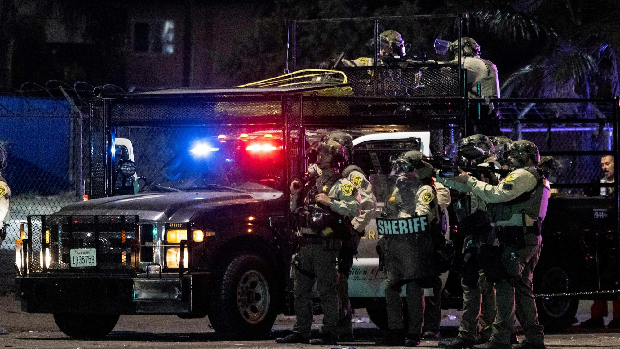Sheriff deputies shoot at demonstrators with less lethal ammunitions during a protest following federal immigration operations, in the Compton neighborhood of Los Angeles, California on June 7, 2025. US President Donald Trump deployed 2,000 troops on June 7 to handle escalating protests against immigration enforcement raids in the Los Angeles area, a move the state's governor termed "purposefully inflammatory." Federal agents clashed with angry crowds in a Los Angeles suburb as protests stretched into a second night Saturday, shooting flash-bang grenades and shutting part of a freeway amid raids on undocumented migrants, reports said. (Photo by ETIENNE LAURENT / AFP)