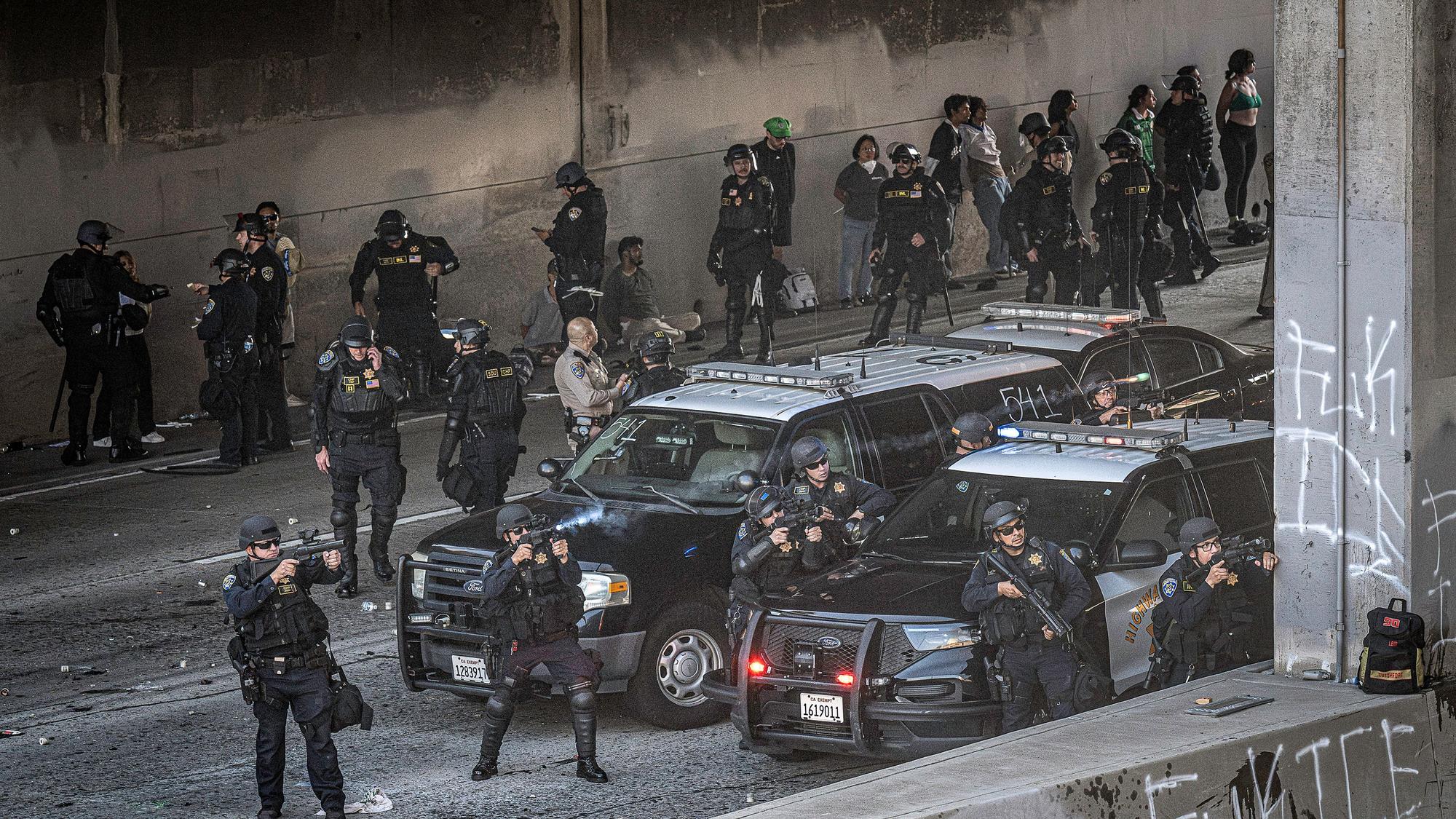 08.06.2025, USA, Los Angeles: LAPD-Polizisten schießen mit nicht-tödlichen Waffen auf eine Menschenmenge einer Demonstration. Seit Tagen wird in Kalifornien gegen Operationen der US-Einwanderungsbehörde ICE protestiert. Foto: Mark Edward Harris/ZUMA Press Wire/dpa +++ dpa-Bildfunk +++