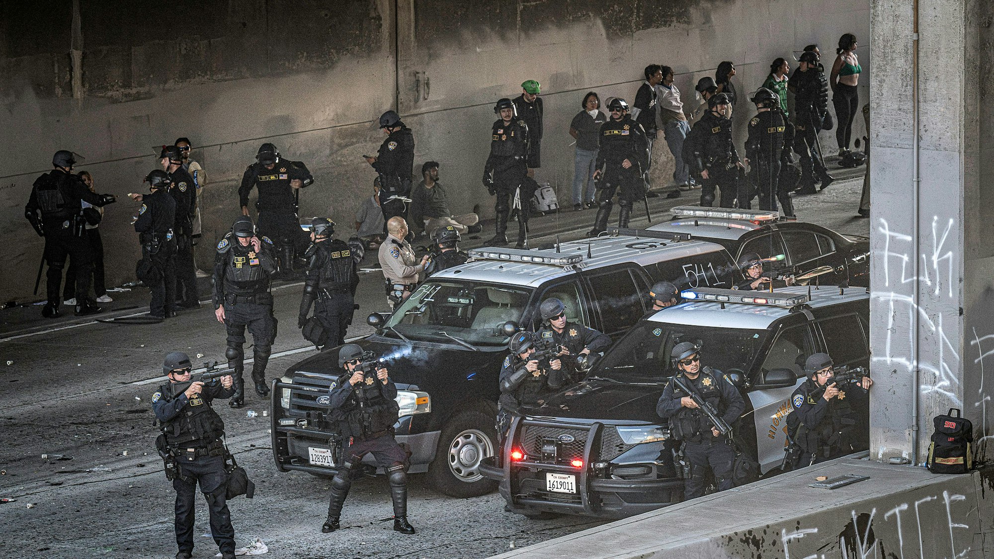 08.06.2025, USA, Los Angeles: LAPD-Polizisten schießen mit nicht-tödlichen Waffen auf eine Menschenmenge einer Demonstration. Seit Tagen wird in Kalifornien gegen Operationen der US-Einwanderungsbehörde ICE protestiert. Foto: Mark Edward Harris/ZUMA Press Wire/dpa +++ dpa-Bildfunk +++