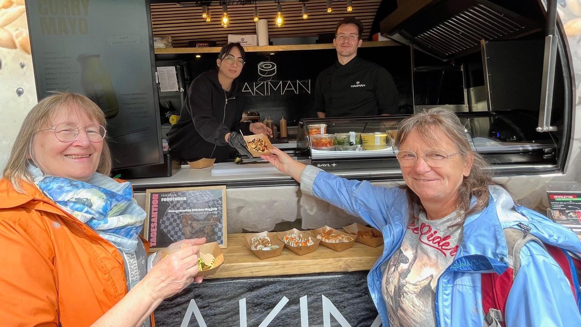 Zu sehen sind zwei Frauen an einem Streetfoodtruck.