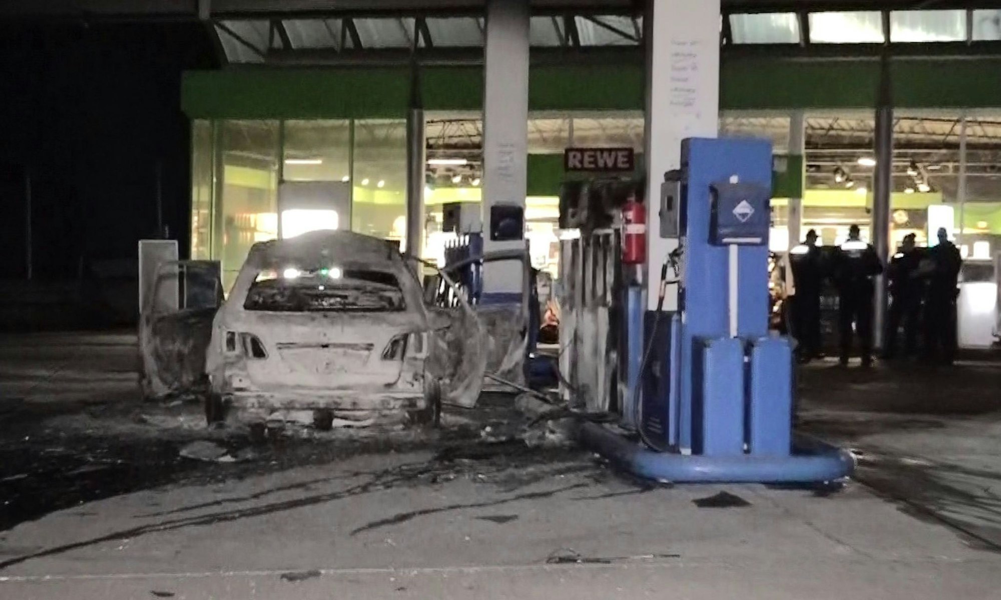 Ein ausgebranntes Fahrzeug steht an einer Zapfsäule auf einer Tankstelle in Hannover.