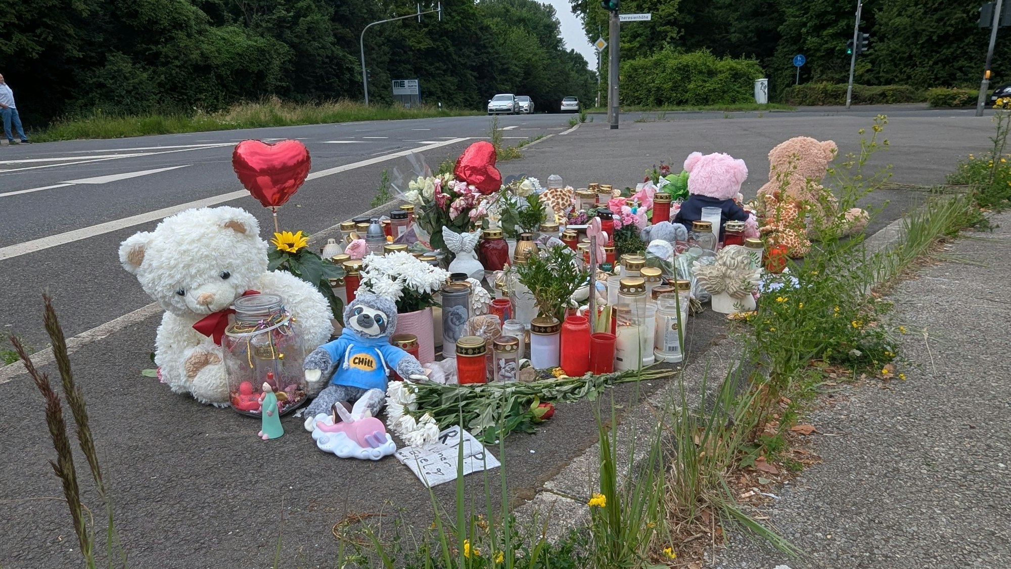 An der Frechener Straße erinnern Blumen, Kerzen, Teddybären, Fotos und Briefe der Mitschüler an das Schicksal der tödlich verunglückten zehnjährigen Avin.