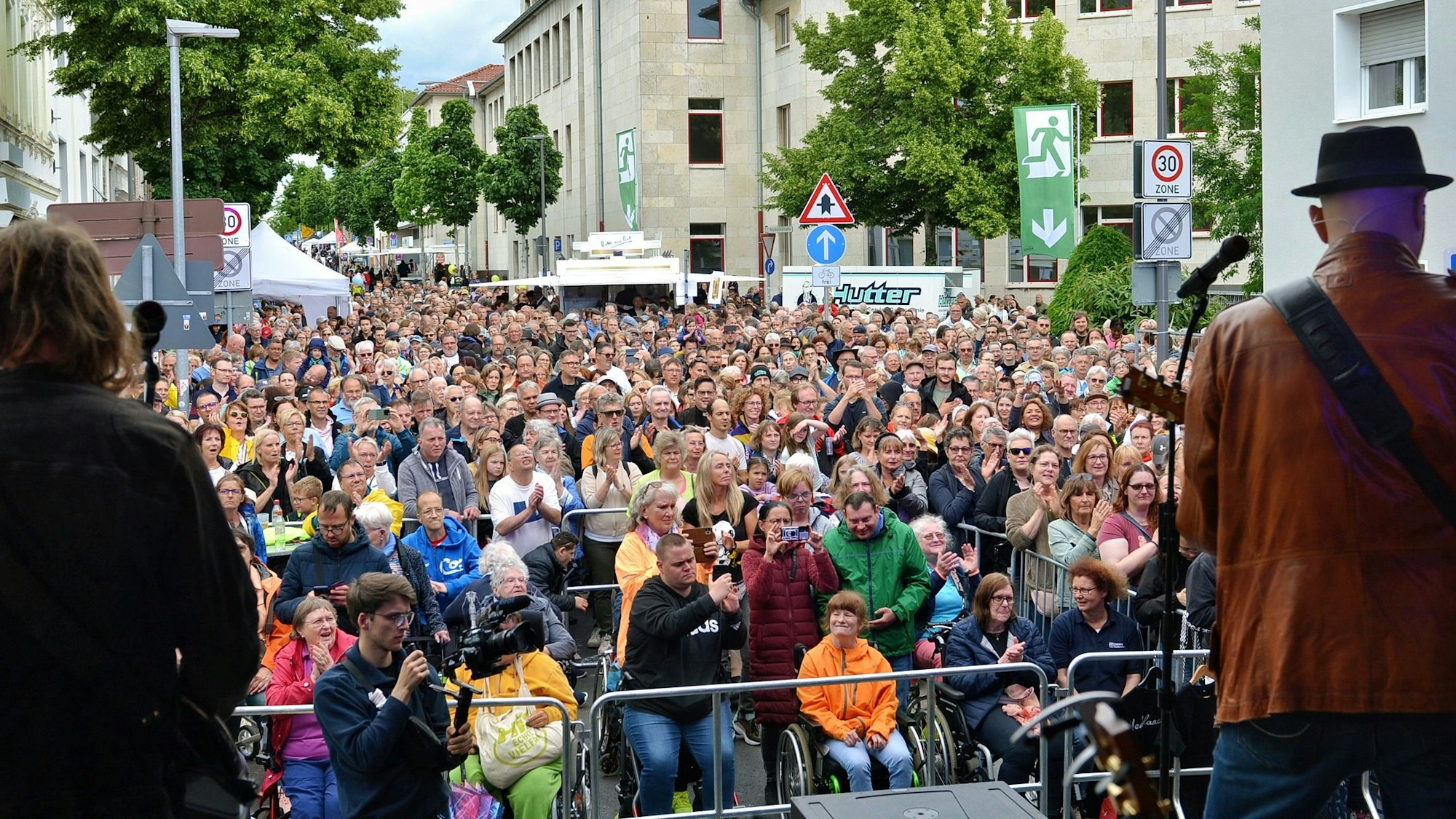 Eine Menschenmenge steht vor einer Bühne.