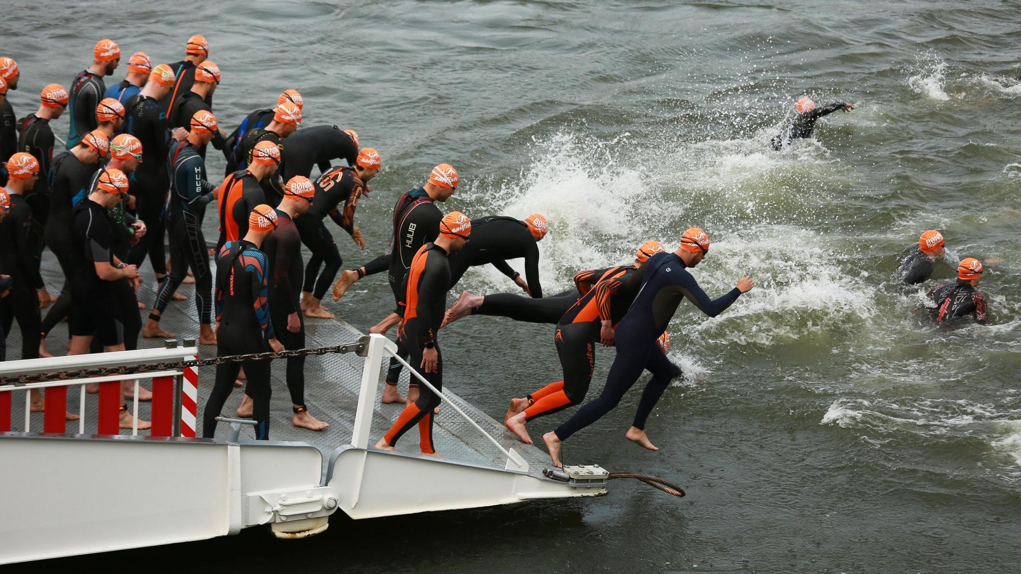 Die Sieger des Bonn-Marathon bei den Männern hatten gut lachen: Der Zweite Thorben Werner, Sieger Nick Emde und der Drittplatzierte Mattia Weßling (Mitte rechts, v.l.). Sie mussten im Rhein schwimmen, im Siebengebirge Rad fahren und durch Bonn laufen.