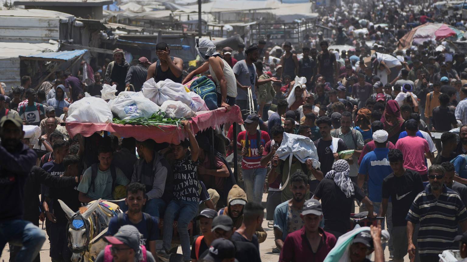 Palästinensische Gebiete, Rafah: Palästinenser tragen Taschen mit Lebensmitteln und humanitären Hilfspaketen