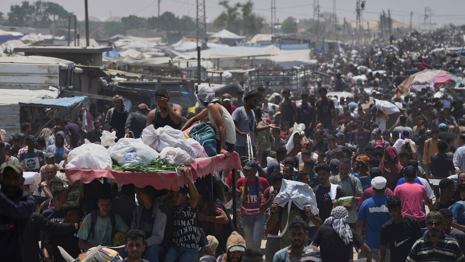 Palästinensische Gebiete, Rafah: Palästinenser tragen Taschen mit Lebensmitteln und humanitären Hilfspaketen