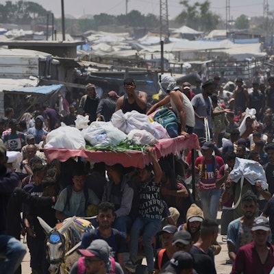 Palästinensische Gebiete, Rafah: Palästinenser tragen Taschen mit Lebensmitteln und humanitären Hilfspaketen