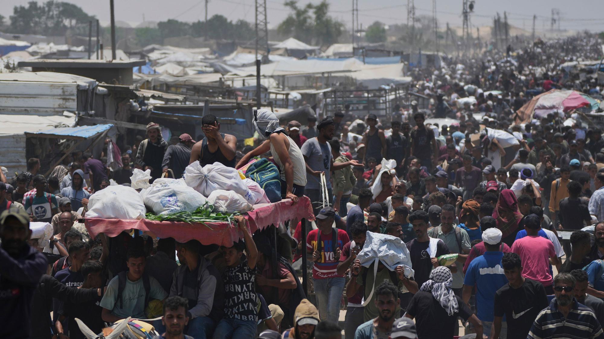 Palästinensische Gebiete, Rafah: Palästinenser tragen Taschen mit Lebensmitteln und humanitären Hilfspaketen