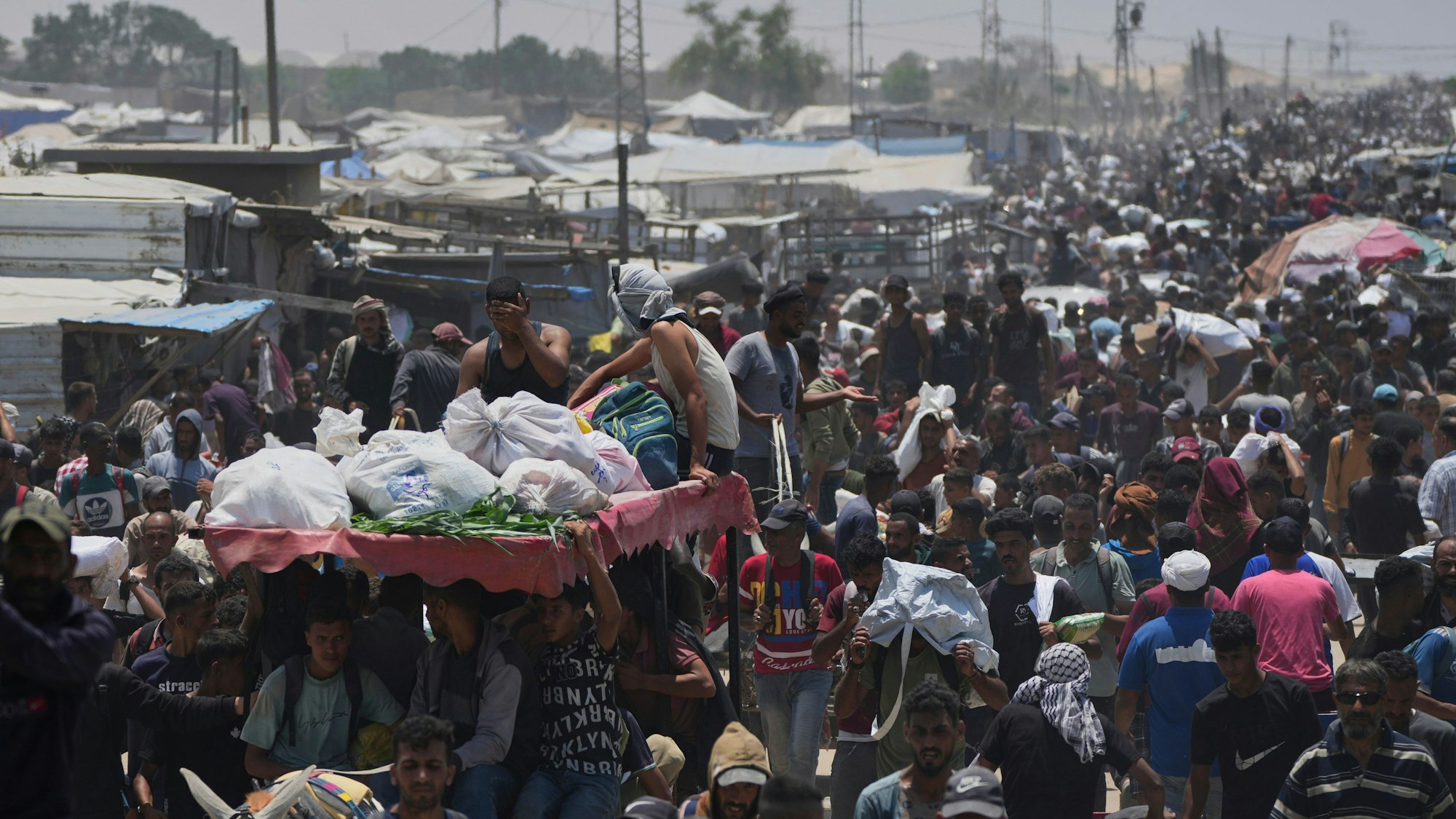 Palästinensische Gebiete, Rafah: Palästinenser tragen Taschen mit Lebensmitteln und humanitären Hilfspaketen