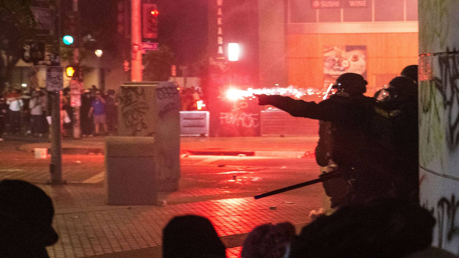 09.06.2025, USA, Los Angeles: Polizisten gehen während der Proteste gegen die Razzien der Trump-Regierung gegen Einwanderer in Los Angeles vor Geschossen in Deckung. Foto: Ethan Swope/FR171736 AP/dpa +++ dpa-Bildfunk +++