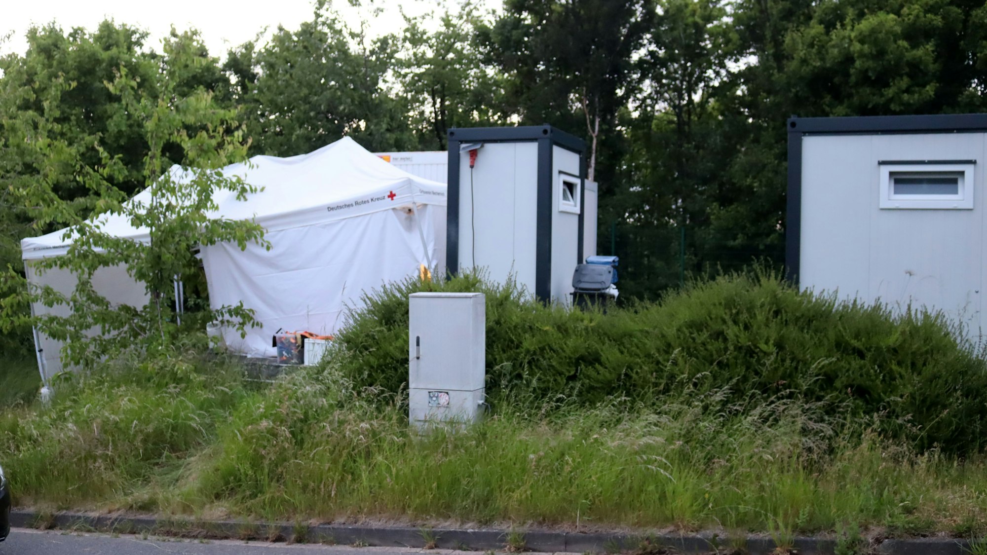 Vor den Wohncontainern der Stadt haben die Ermittler der Bonner Polizei ein weißes Zelt aufgebaut.