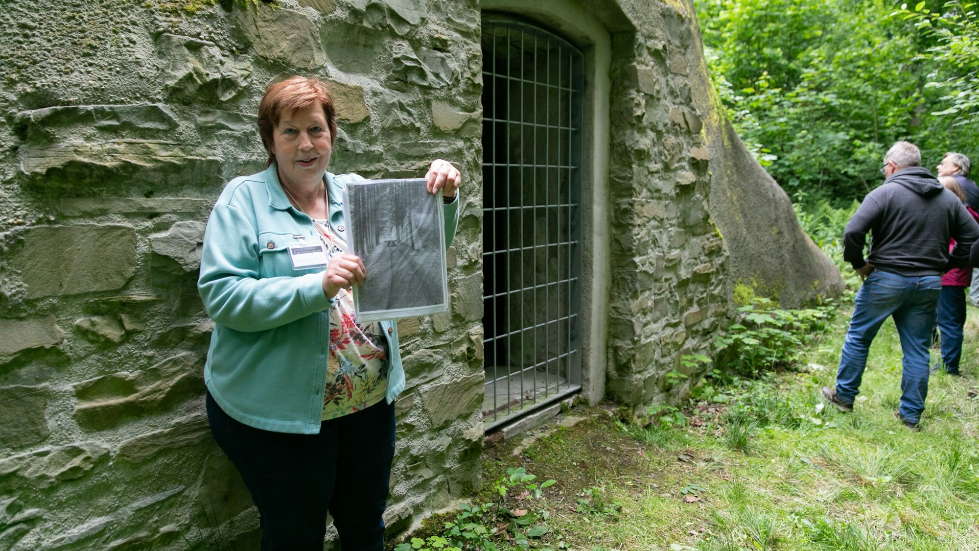 Eine Frau hält ein historisches Foto in den Händen.