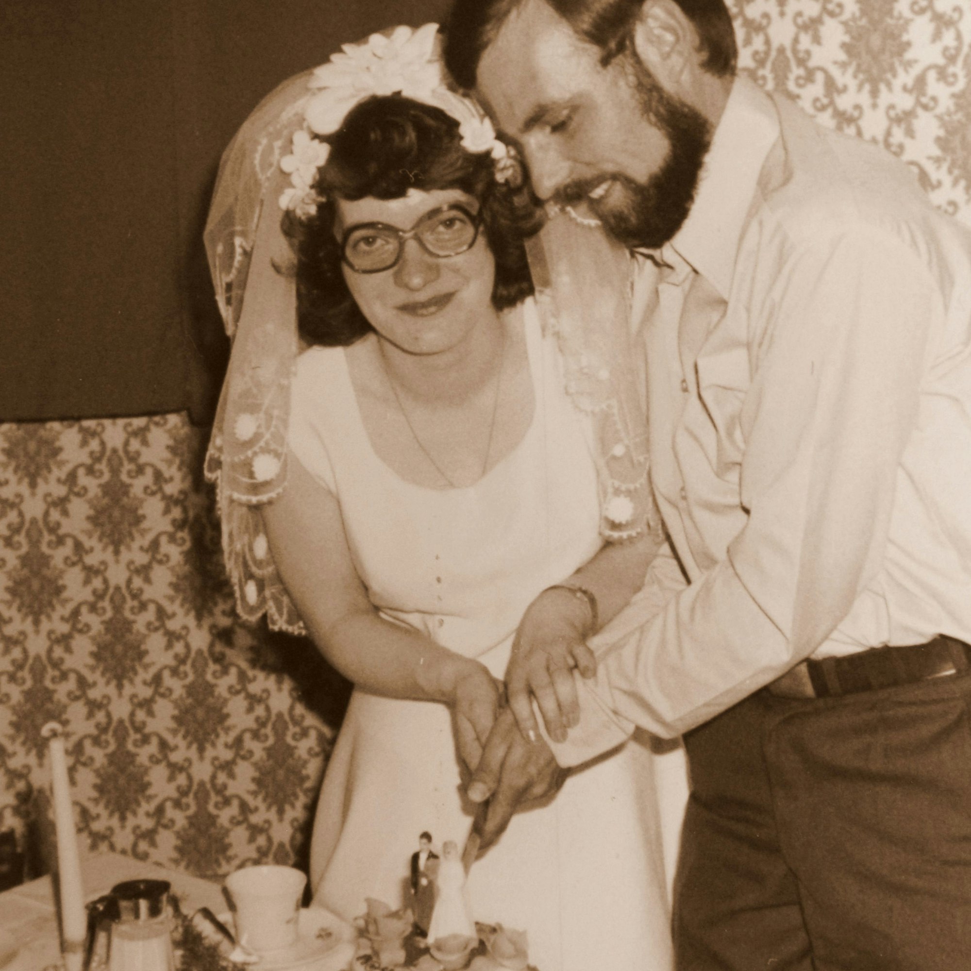 Die frisch Vermählten schneiden die Hochzeitstorte an.