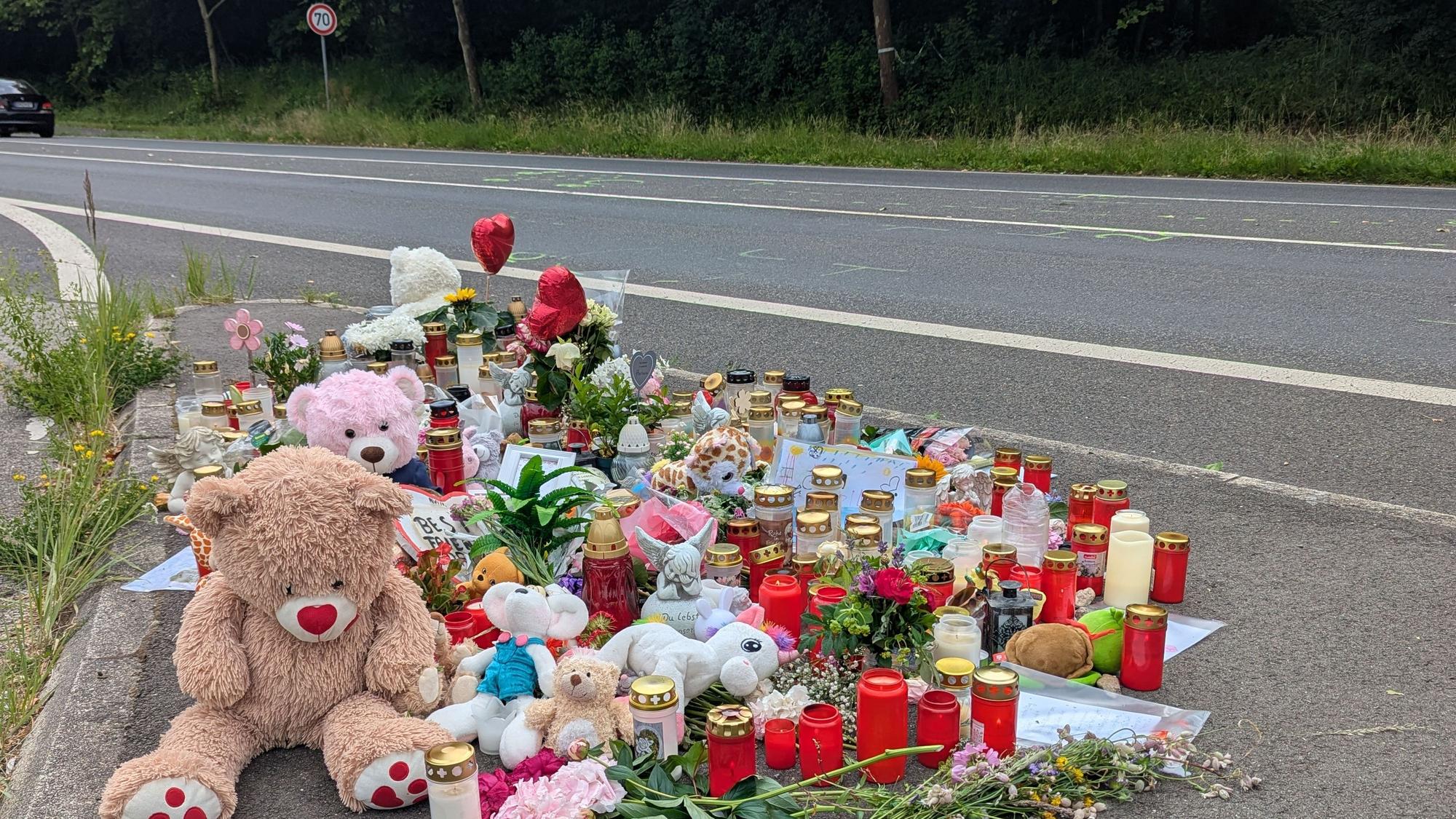 An der Unfallstelle an der Ampel Frechener Straße/Theresienhöhe erinnern Blumen, Kerzen, Teddybären, Fotos und Briefe der Mitschüler an das Schicksal des tödlich zehnjährigen Mädchens.