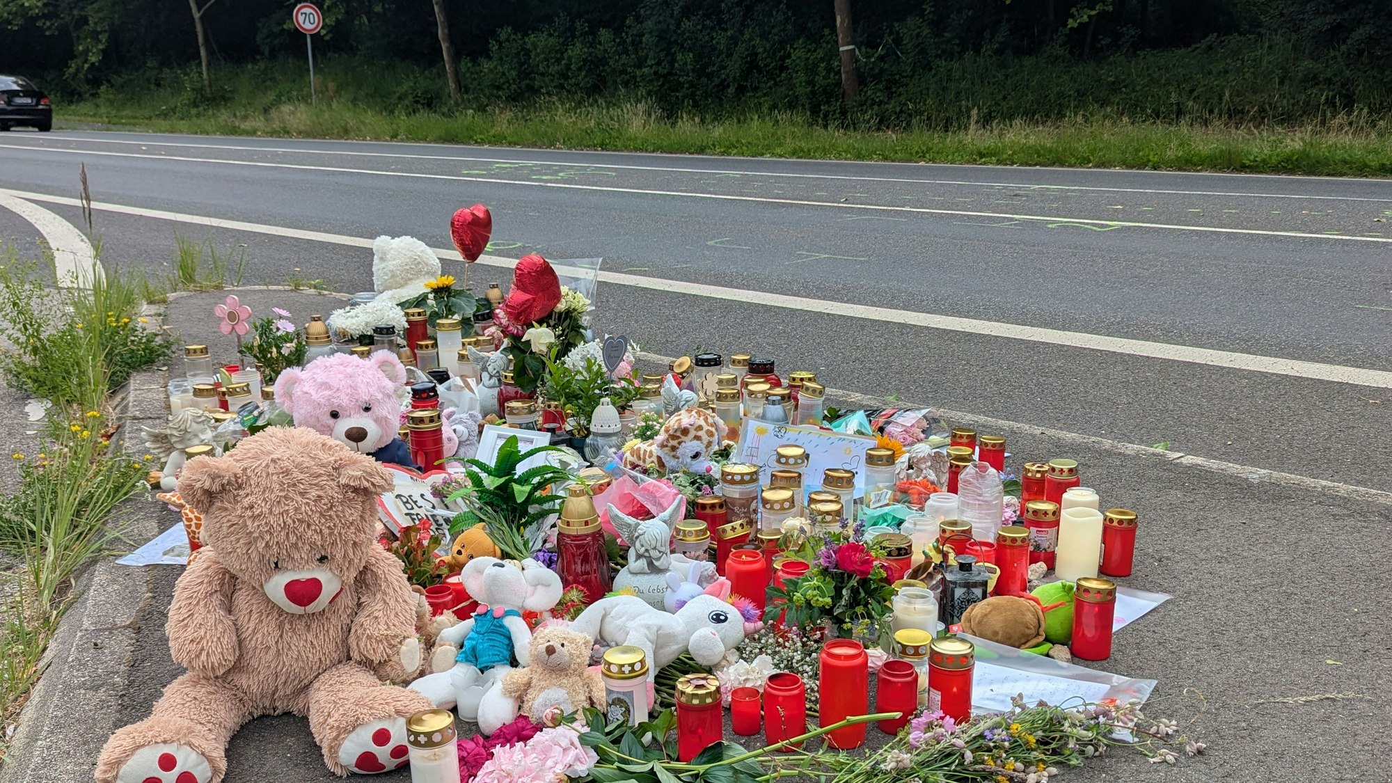 An der Unfallstelle an der Ampel Frechener Straße/Theresienhöhe erinnern Blumen, Kerzen, Teddybären, Fotos und Briefe der Mitschüler an das Schicksal des tödlich zehnjährigen Mädchens.