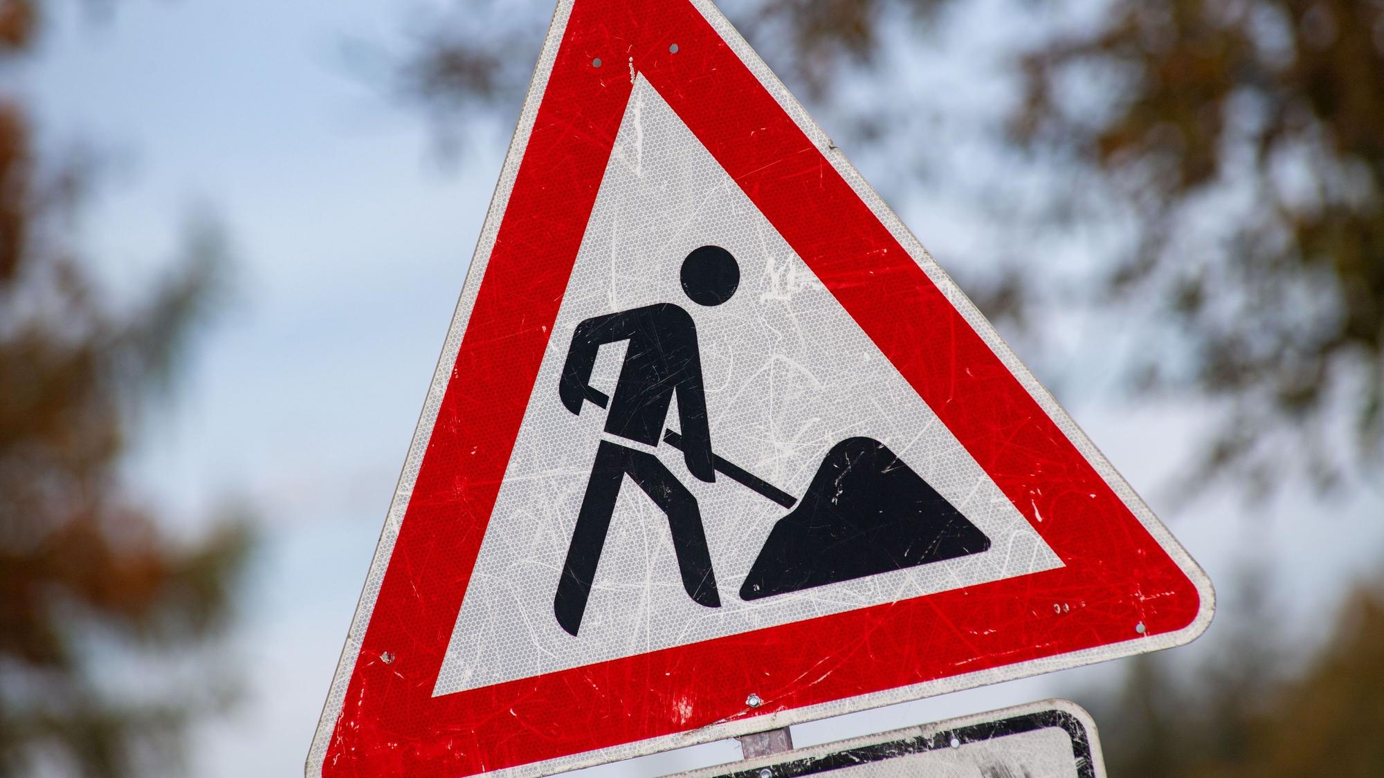 Ein zerkratztes Schild Gefahrenzeichen Arbeitsstelle mit dem Piktogramm eines Bauarbeiters zur Beschilderung einer Baustelle